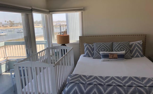 crib next to bed in bedroom