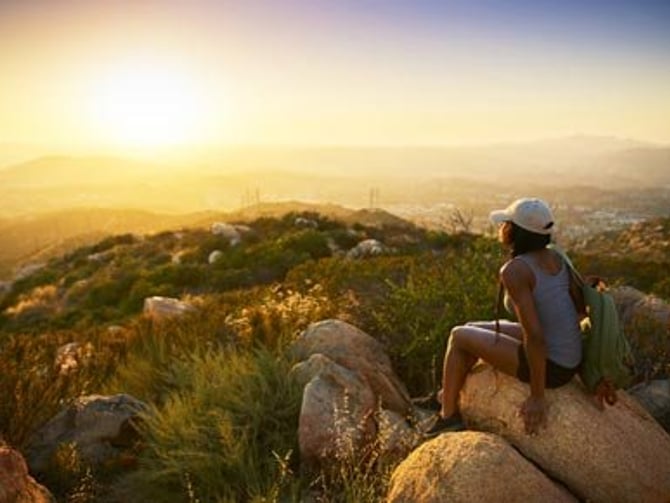 Hiker watching sunset over San Diego hills